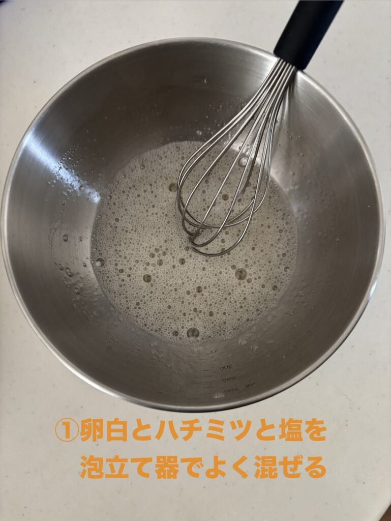 卵白、ハチミツ、塩を泡だて器で混ぜている様子